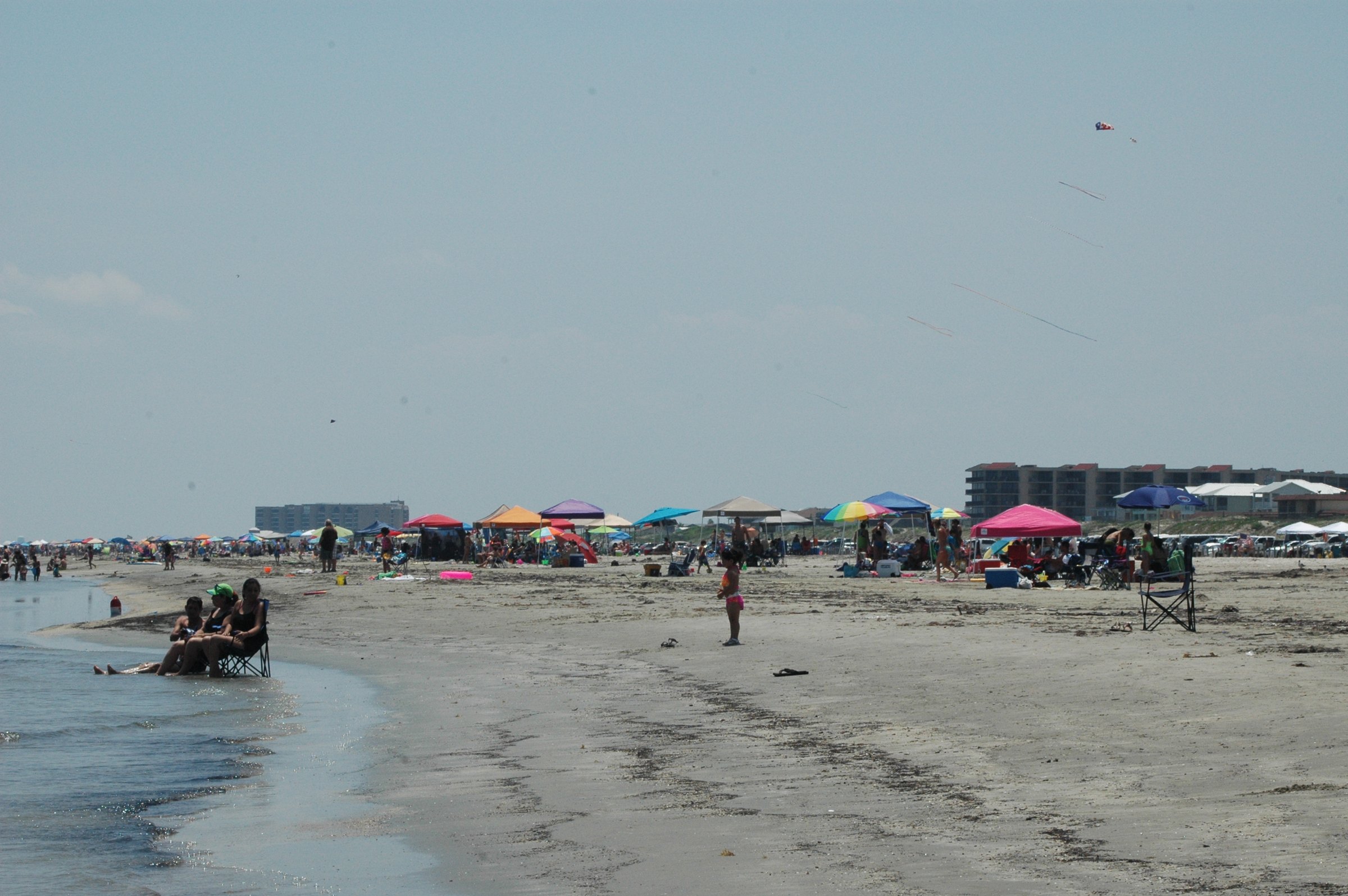 A beach day in Port Aransas, with canopies and kites on the sand